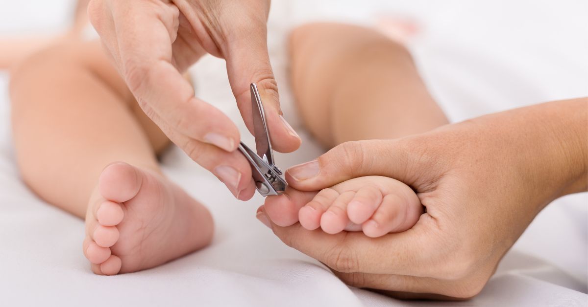 A mother clips her baby's toenails.
