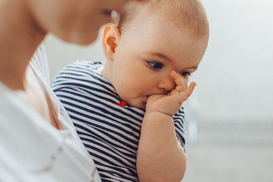 A baby is sucking his thumb.