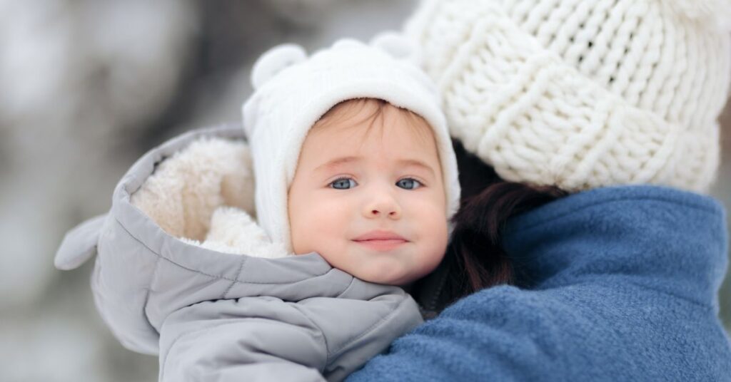 A baby dressed in warm clothes for cold weather.