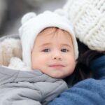 A baby dressed in warm clothes for cold weather.