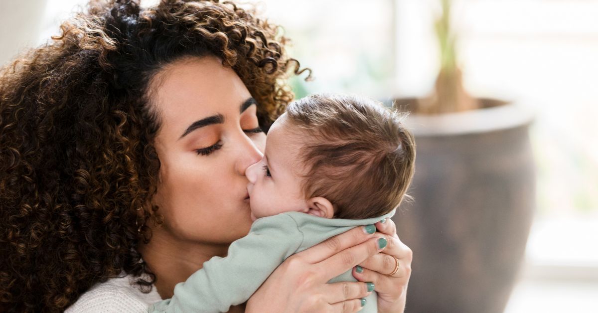 A mother kisses her baby's face.