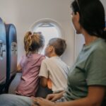 Children on an airplane look out the window.