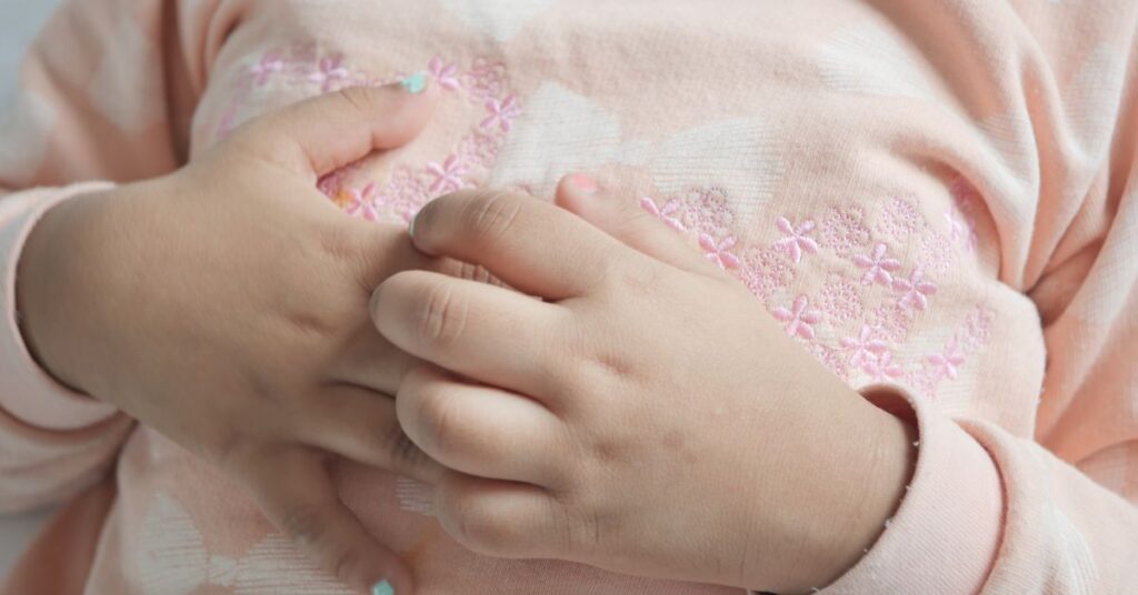 A girl scratches her hands.