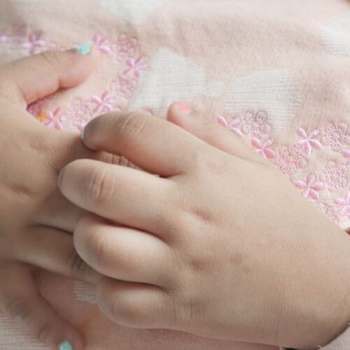 A girl scratches her hands.