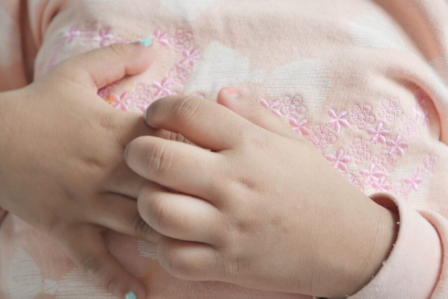 A girl scratches her hands.