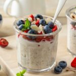 Glass jars of overnight oats and chia seeds topped with fruit.