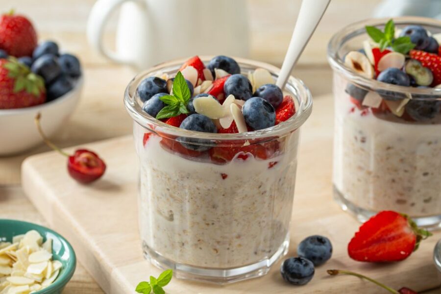 Glass jars of overnight oats and chia seeds topped with fruit.