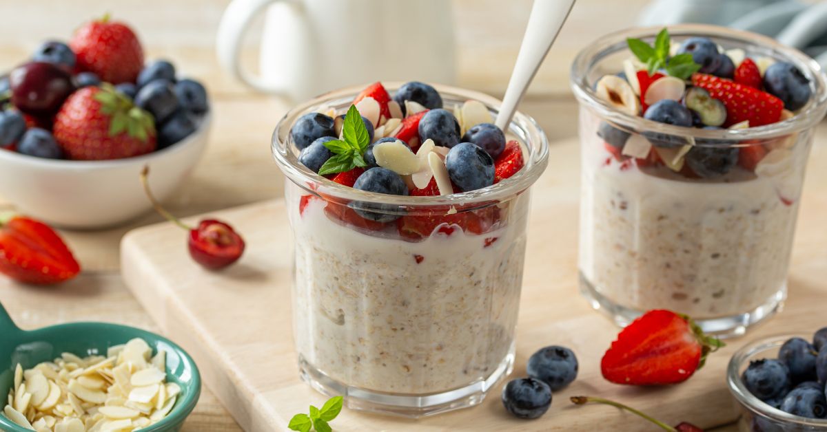 Glass jars of overnight oats and chia seeds topped with fruit.