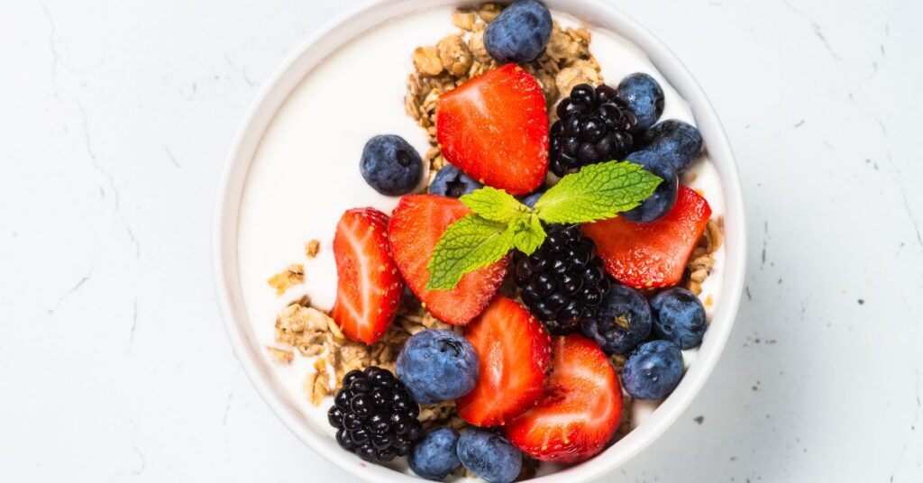 A bowl of yogurt with fruit and granola.