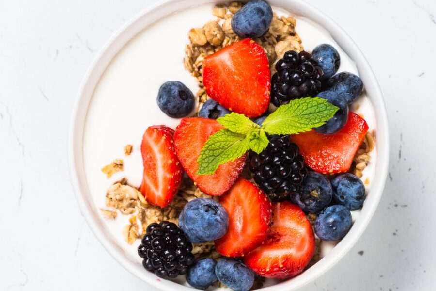 A bowl of yogurt with fruit and granola.