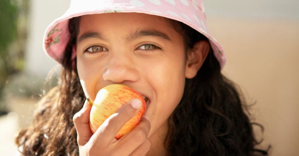 A girl eats an apple.