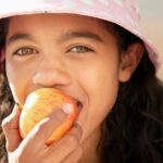 A girl eats an apple.
