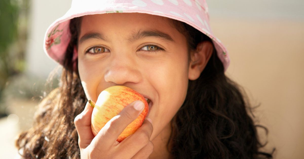 A girl eats an apple.
