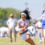 A teenage girl plays flag football.