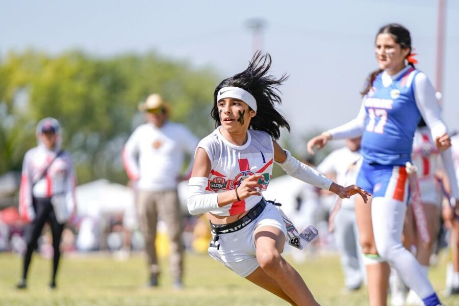 A teenage girl plays flag football.