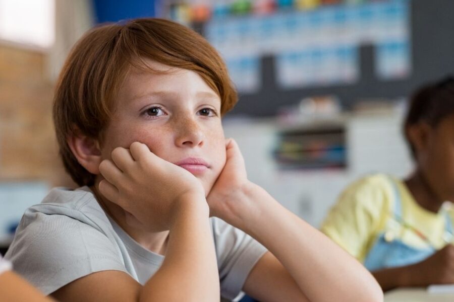 A boy stares off into space at school.