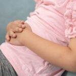 A close up of a young girl holding her stomach.